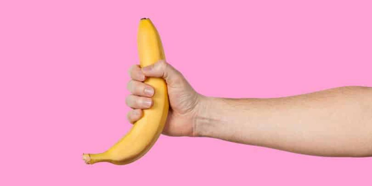Banana as a symbol of male penis in hand on a yellow background hidden by censorship. Sexual masturbation and orgasm, impotence problem. Self-pleasure concept.
