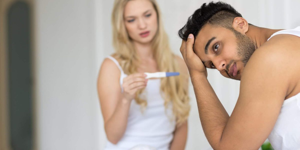 Young Couple Sitting In Bed, Woman Show Man Positive Pregnancy Test Conflict Relationships Problem